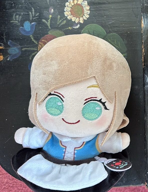 Light-brown-haired BestaJuni doll with green eyes wearing a blue bunad