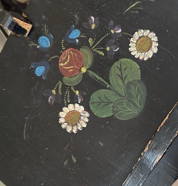 Hand-painted rosemaling flowers on a black wooden bench